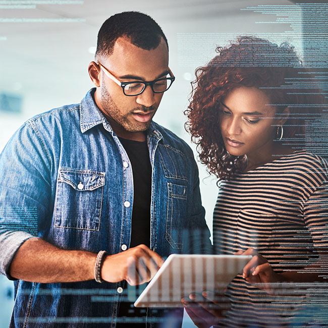 Two colleagues evaluating information on a tablet