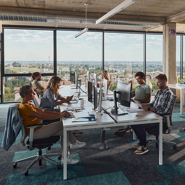 Large group of programmers working in a modern office of a software company. Copy space.