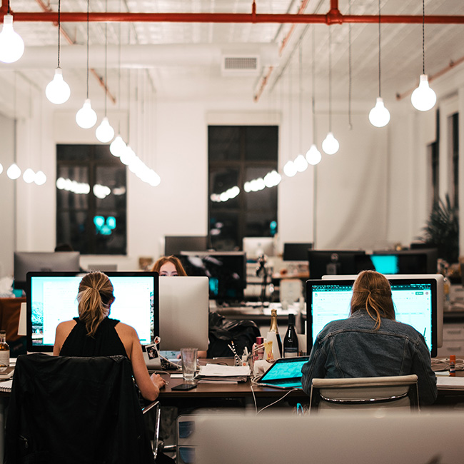 Colleagues work on computers in a modern office setting