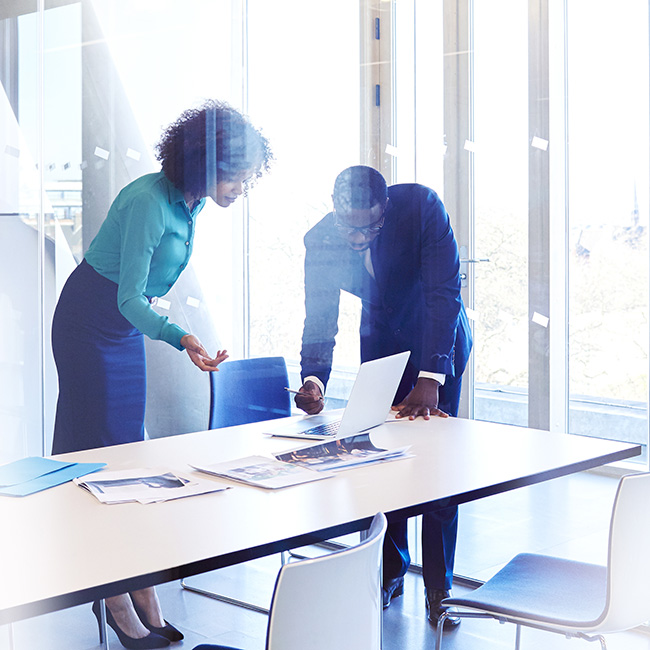 A man and a woman standing around a table, engaged in conversation