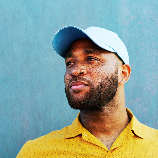 A man in a bright yellow shirt gazes off to the side