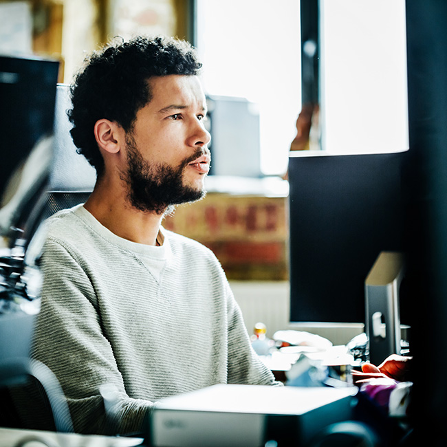 Young casual businessman portrait working on a computer