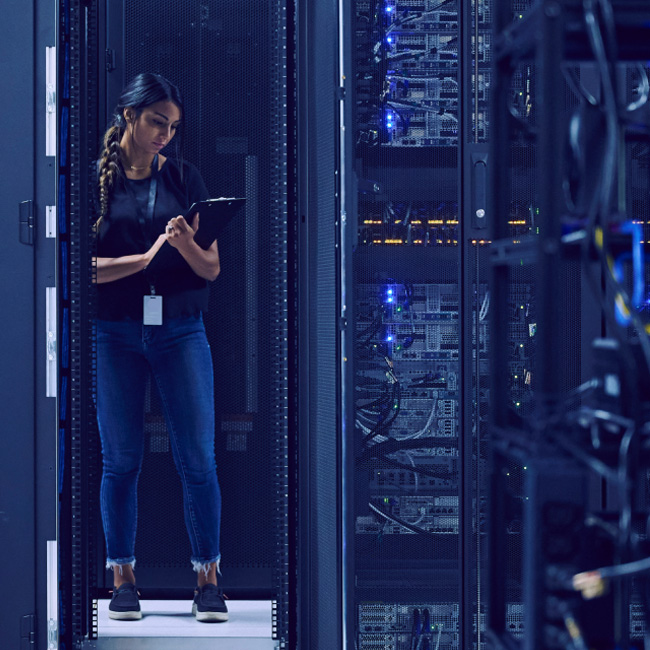 A woman is depicted standing in a server room, holding a tablet device.