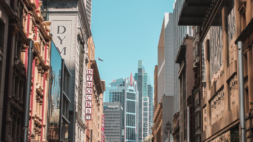 Urban landscape with towering skyscrapers and a prominent street sign.