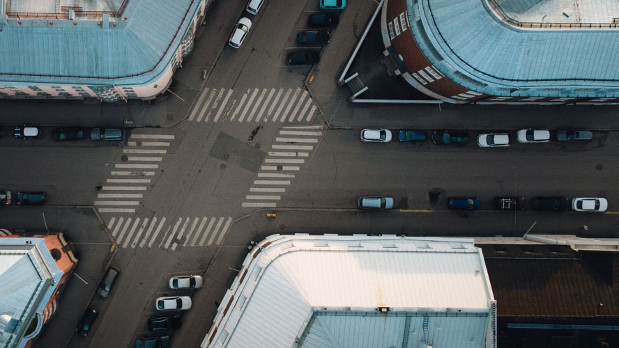 An aerial perspective of a bustling cityscape, showcasing vehicles and towering structures in a vibrant urban setting.