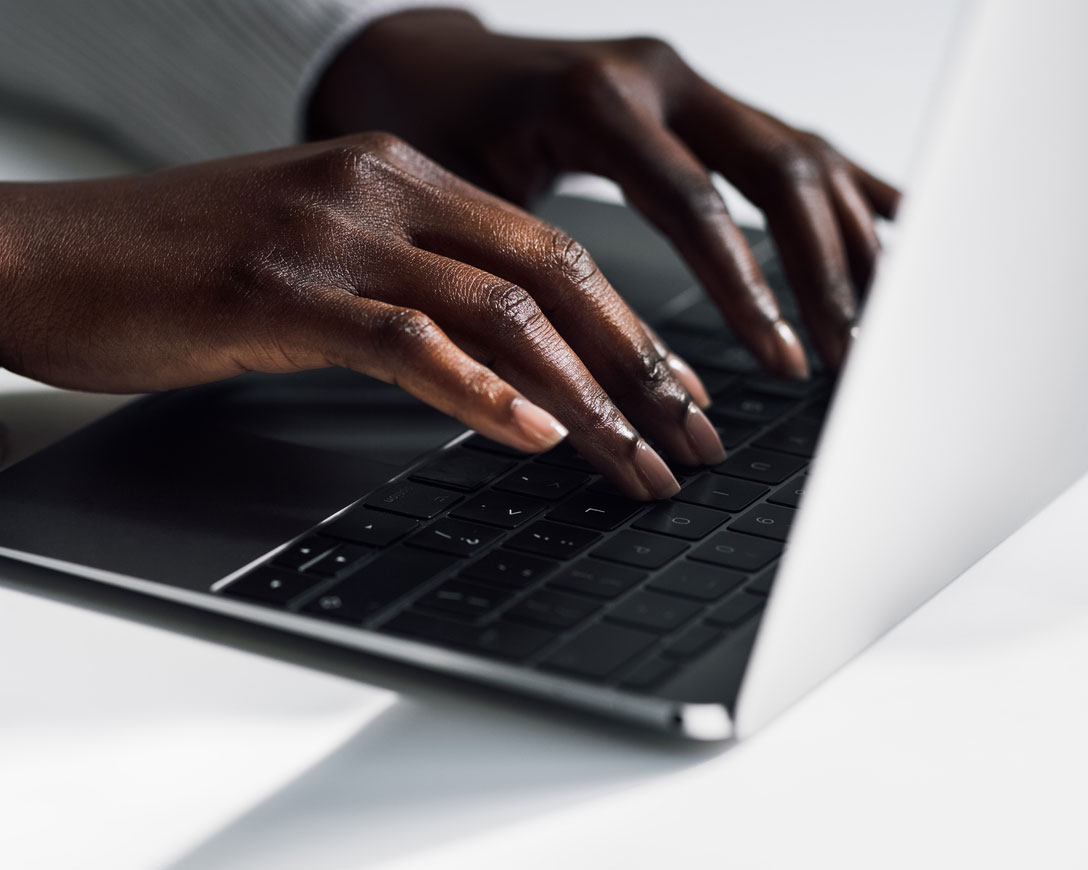 Close up of woman's hands typing on laptop, focused and determined.