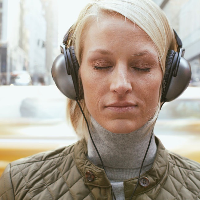 A woman wearing headphones, engrossed in her music, enjoying a moment of auditory bliss.