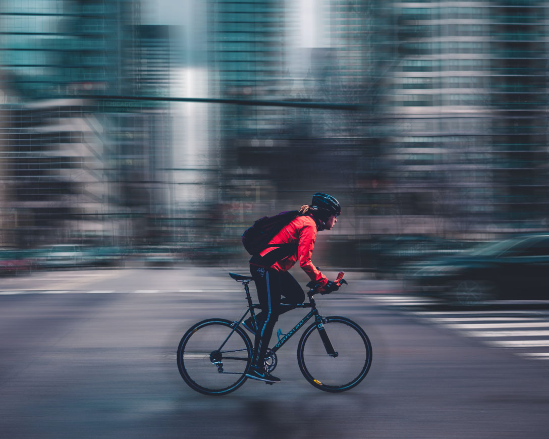 A cyclist navigating through a busy city street on a bike.