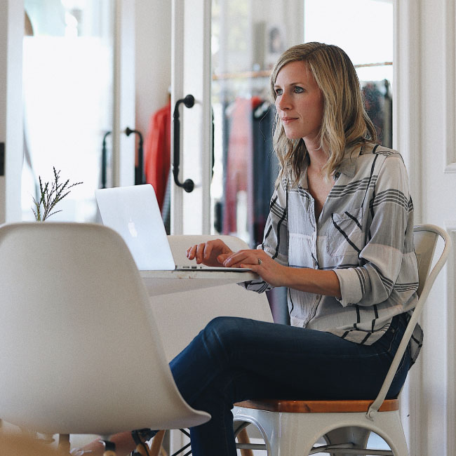 Woman using laptop while sitting on chair.