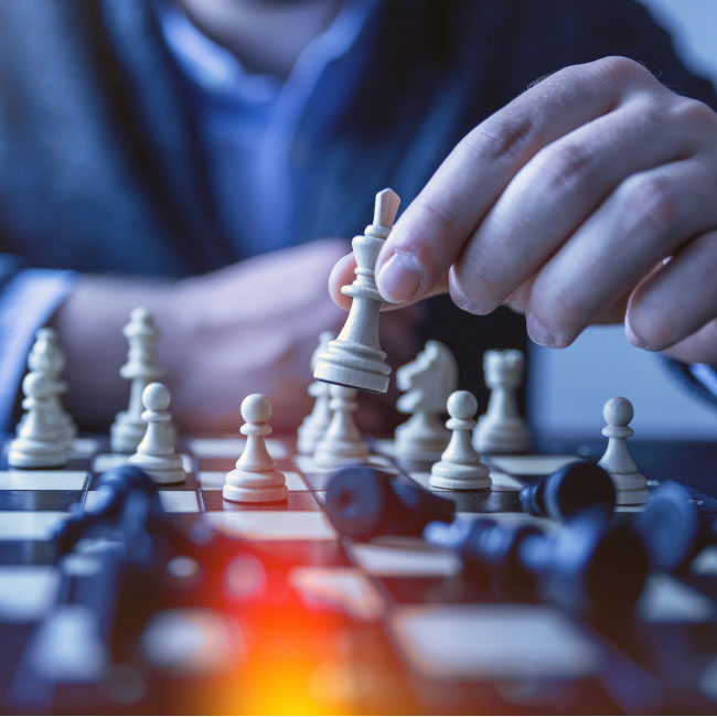 A man strategically moves a chess piece on the board, engaged in a game of intellect and strategy.